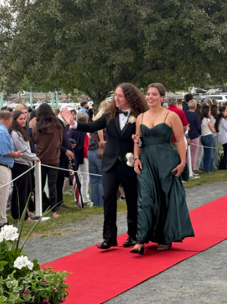 Luke Burke waves to the crowd as he walks with Aubrey Fairfield.