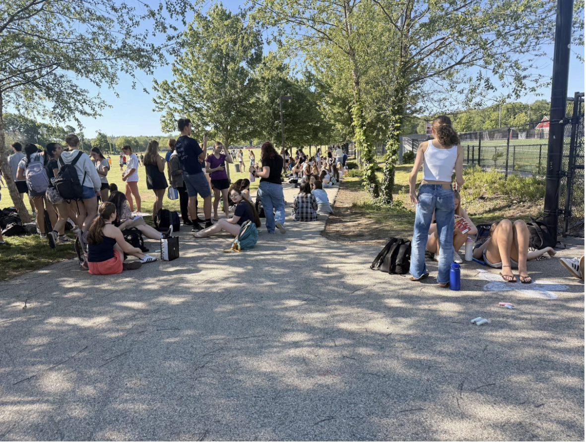 Hingham High students crowd the sidewalk to enjoy the sun.