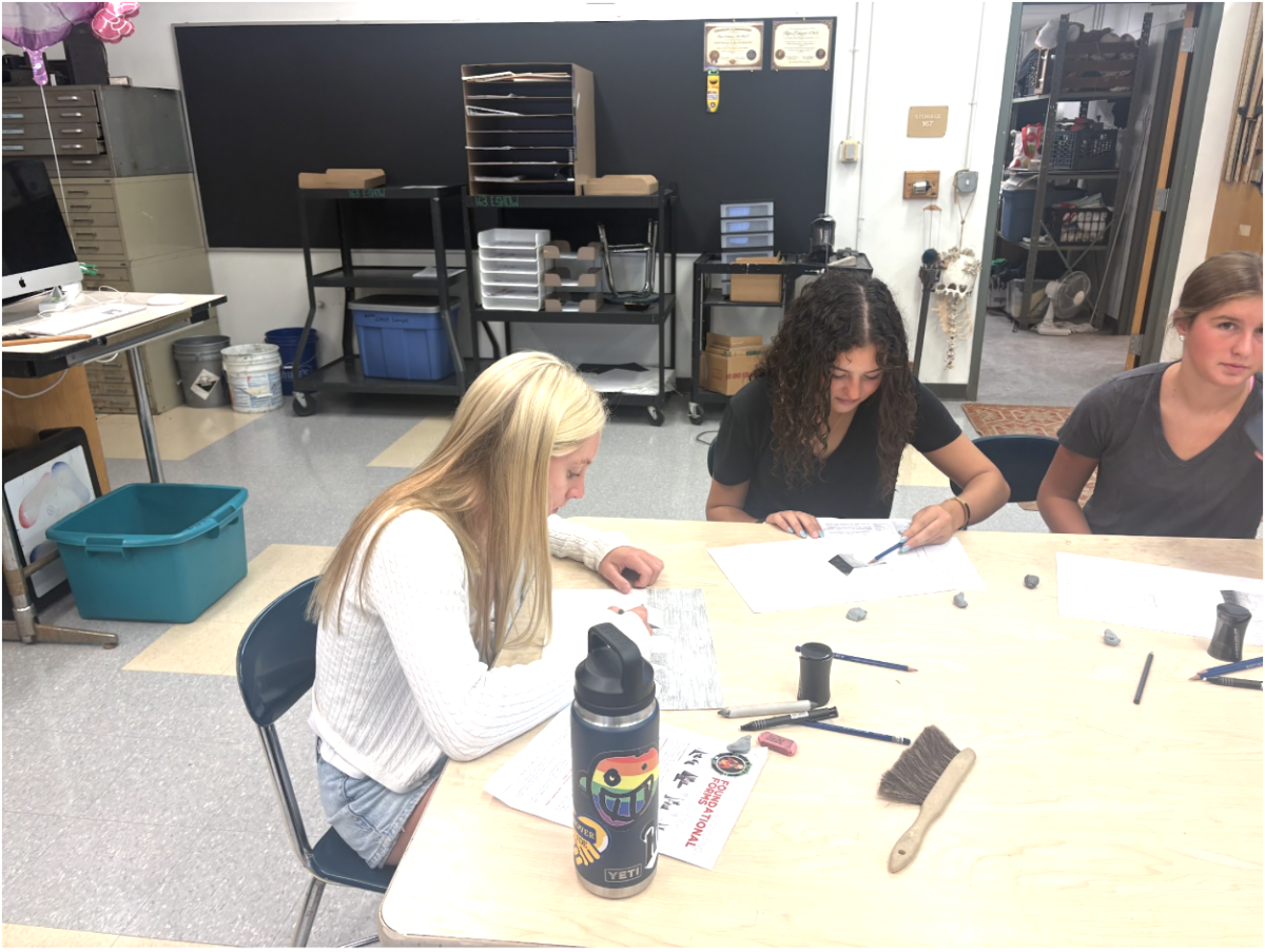 Students Margot Wiebly and Emily Koskinas sketch sophisticated pictures of shaded 3-D shapes.