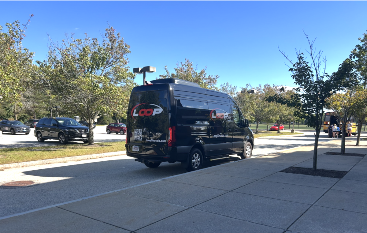 A Loop Shuttle outside the front entrance of Hingham High School ready to provide after-school transportation services.