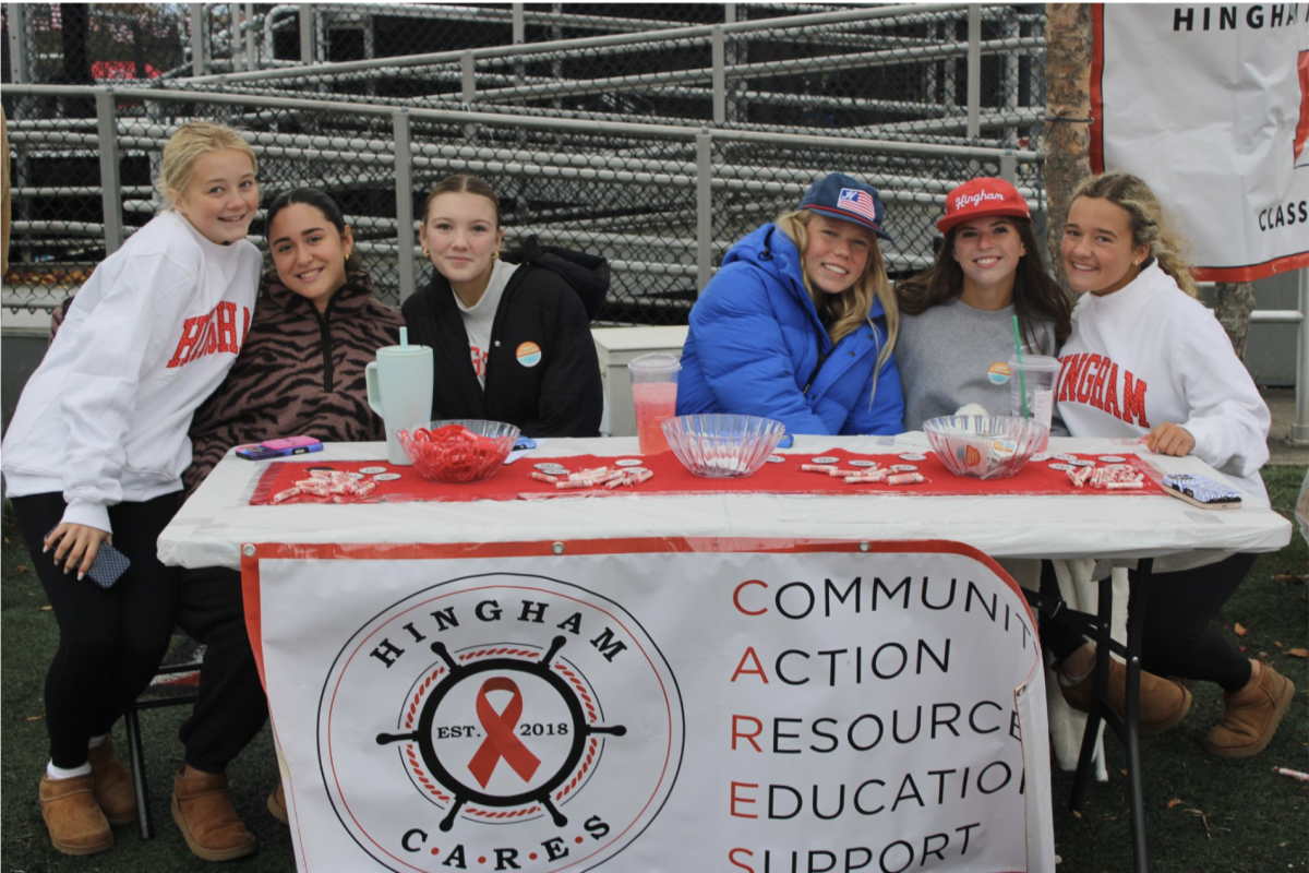 Students pose in front of the Hingham Cares table, advocating against destructive decisions